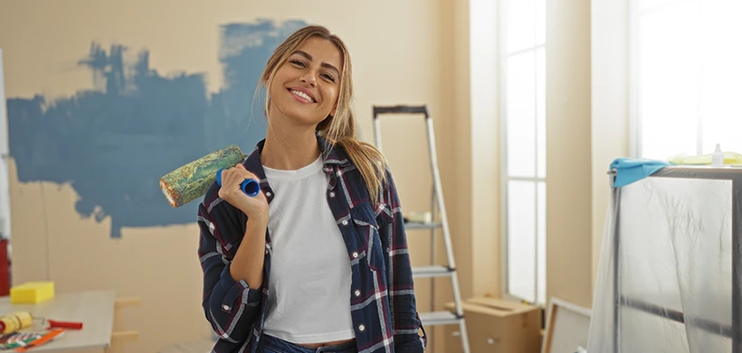 Mujer pintando y remodelando su apartamento con el subsidio de Colsubsidio.