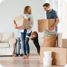 Una pareja carga cajas y con su perro entran a su vivienda adquirida con el subsidio arrendamiento.