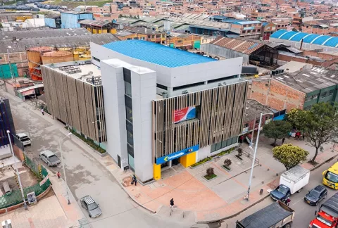 Vista aérea de BLOC Bosa Colsubsidio muestra un edificio gris, techo azul, en un entorno urbano.