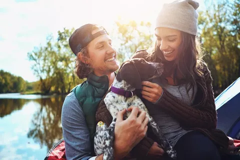 Pareja con mascota haciendo actividades al aire libre