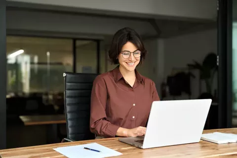 Mujer sonriendo frente al computador