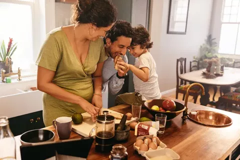 Familia prepara la cena en su cocina renovada gracias al servicio postventa de vivienda Colsubsidio.