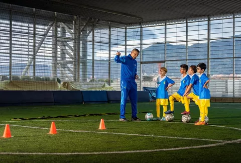 Entrenador explica técnicas de fútbol a sus estudiantes.