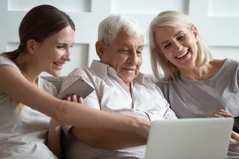 Familia con adulto mayor revisan su afiliación desde computador