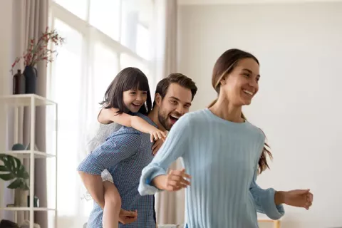 Familia feliz juega en la sala de su vivienda Colsubsidio