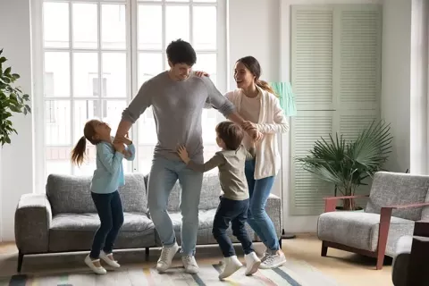 Familia feliz juega en la sala de su vivienda Colsubsidio