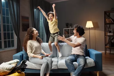 Familia juega en la sala de su vivienda Colsubsidio