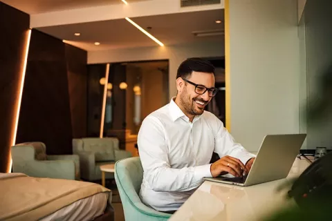 Hombre sonriendo frente a su computador