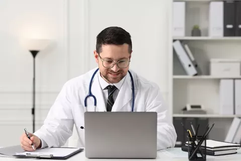 Médico revisa el historial médico en su portátil