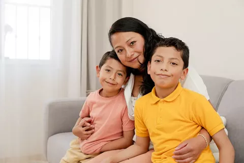 Madre juega con sus hijos en la sala de su vivienda Colsubsidio
