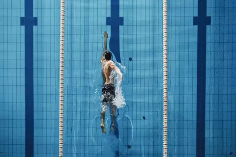 Trabajador nada en las piscinas Colsubsidio