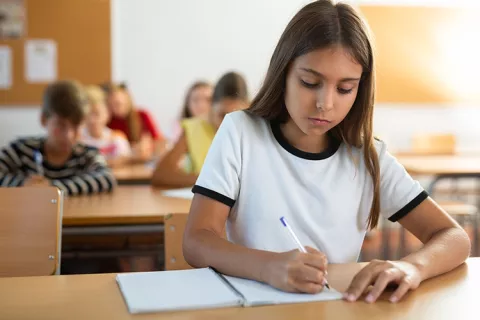 Niña escribiendo en su cuaderno