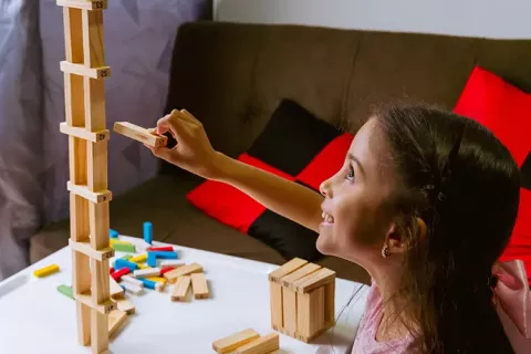 Niña juega jenga