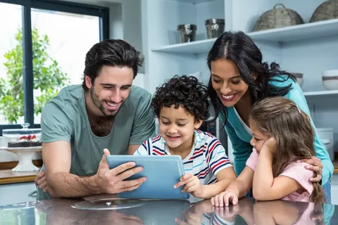 Padres con sus hijos revisando la tablet