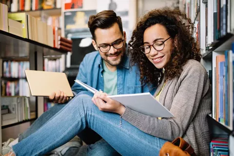 Una pareja lee en la biblioteca Colsubsidio, rodeada de libros