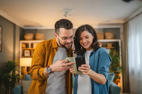 Pareja sonriendo y viendo el celular