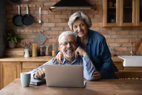 Personas pensionadas revisan su afiliación Colsubsidio desed el portátil