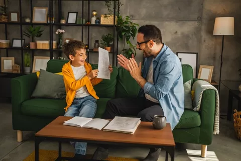 Padre e hijo celebrando notas en colegios Colsubsidio