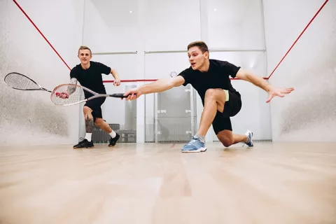 Dos hombres practicando squash 