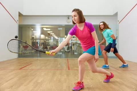 Mujer aprendiendo squash