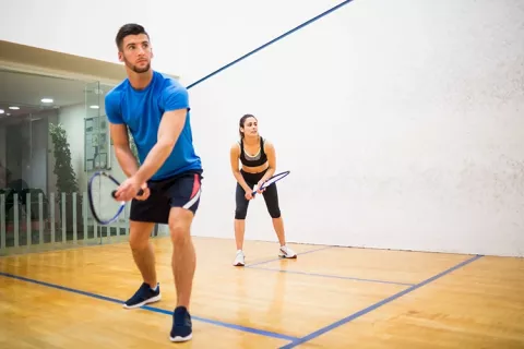 Mujer y hombre practicando squash