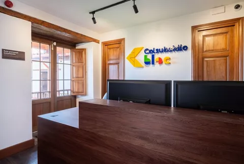 Salón BLOC Maiporé de Colsubsidio muestra una recepción de madera con logos coloridos en la pared.