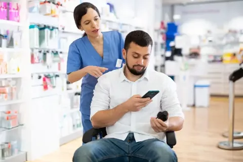 Una persona en condición de discapacidad adquiriendo medicamentos en una droguería incluyente de Colsubsidio.