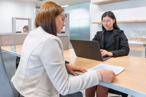 Mujer lee documentos de la Agencia de Empleo Colsubsidio con su asesora
