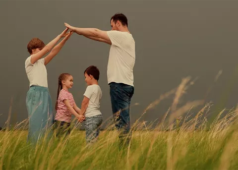 Familia feliz haciendo figura de una casa