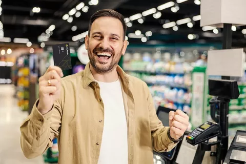 Hombre feliz mostrando su tarjeta de afiliación colsubsidio