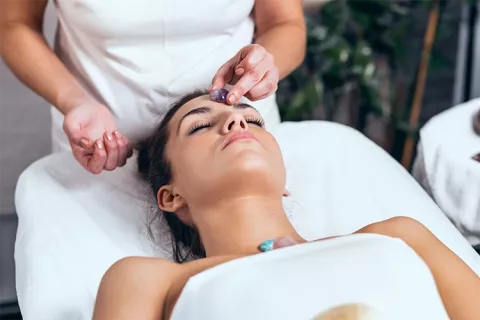 Mujer recibiendo tratamiento con piedras en cuerpo
