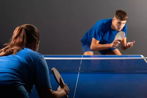 Dos jugadores de tenis de mesa concentrados en su partido.