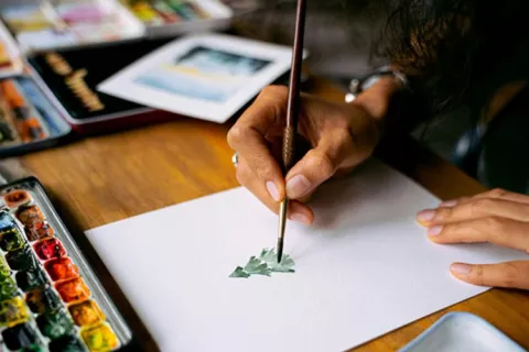 Persona pintando un árbol con acuarela
