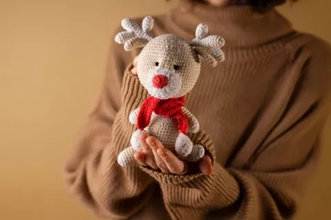 Persona sostiene un muñeco navideño