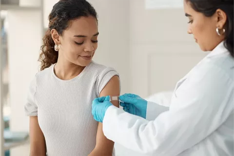 Mujer siendo vacunada en el brazo