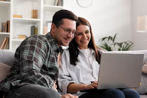 Mujer y hombre ven la pantalla de un computador portátil