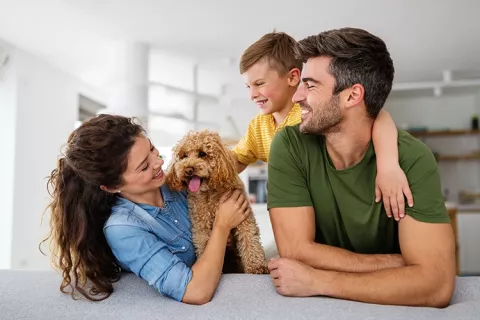 Familia el sofá acompañados por su perro