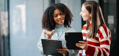 Dos personas hablando y viendo una tablet