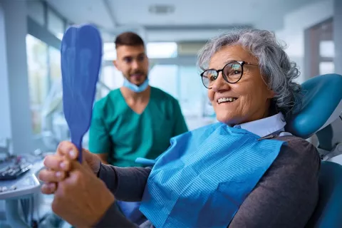 Adulta mayor revisa su diseño de sonrisa.