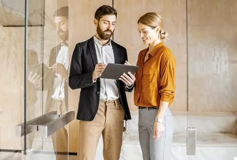 hombre y  mujer revisando tablet