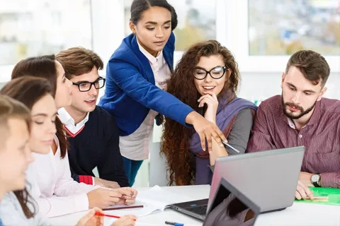 Grupo de estudiantes presentando su proyecto al profesor.