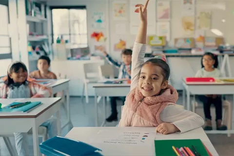 Niñas de colegio participando en clase.