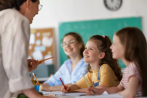 Niñas sonrientes en clase con su profesora.