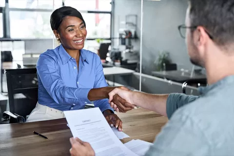 Asesora financiera sosteniendo la mano de su cliente