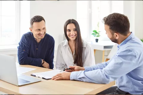 Pareja conversando con asesor de crédito de vivienda