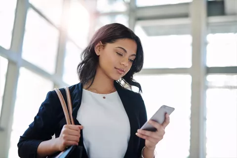 mujer pagando desde su celular las cuotas fijas del crédito hipotecario Colsubsidio