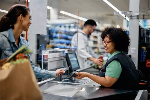 Mujer pagando en establecimientos comerciales con el cupo de crédito Colsubsidio