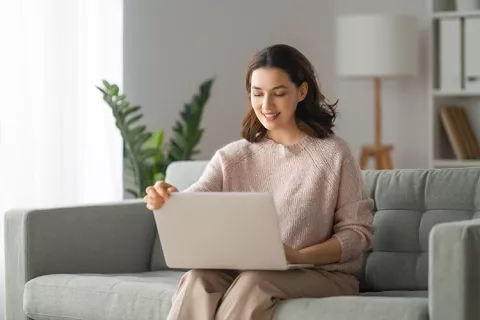 Mujer en su portátil finalizando la solicitud en línea del crédito para mujeres