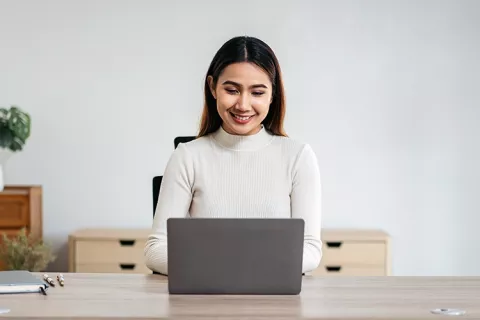 Mujer en su portátil solicitando crédito mujeres.