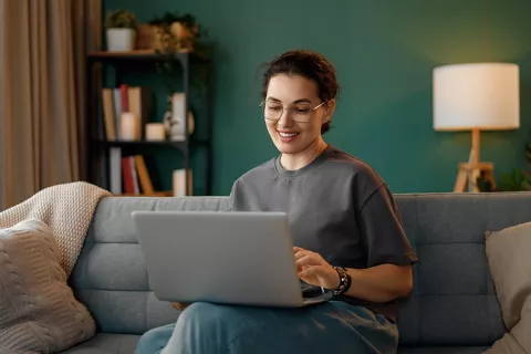 Mujer en su portátil consultando la solicitud del crédito hipotecario de Colsubsidio